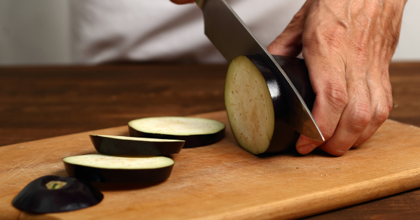 slicing eggplant on cutting board