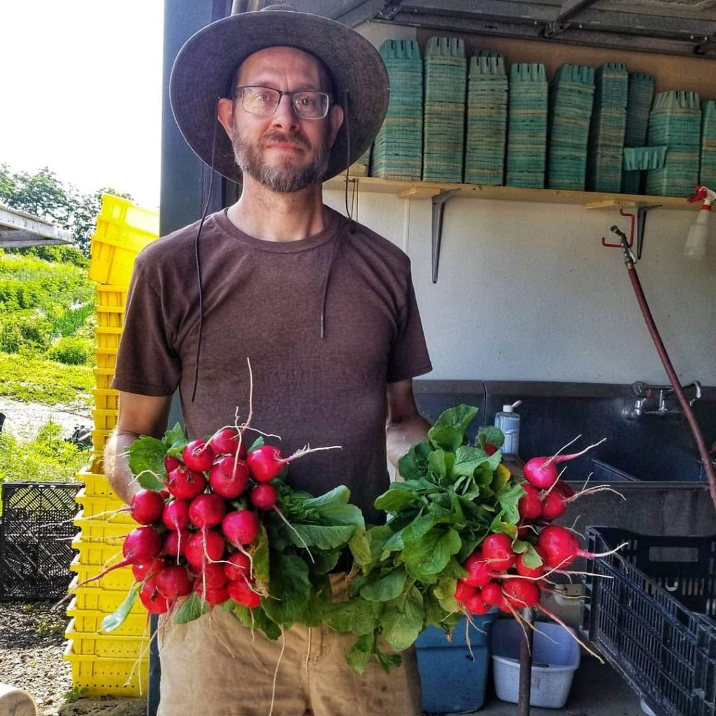 farmer Reuben holding full bunches of Radish