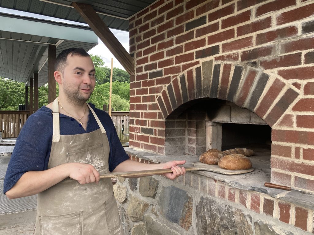 Vince baking organic sourdough bread in brick oven